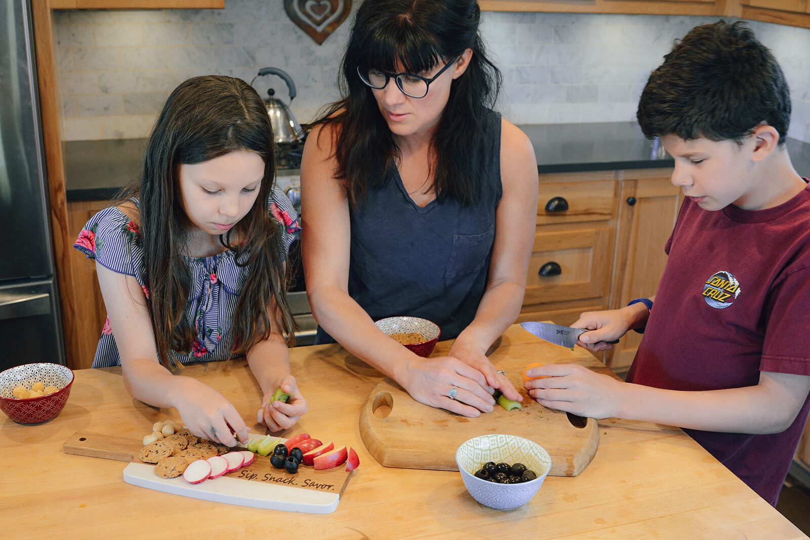 Chelsea Britton cooking at the counter with her two children