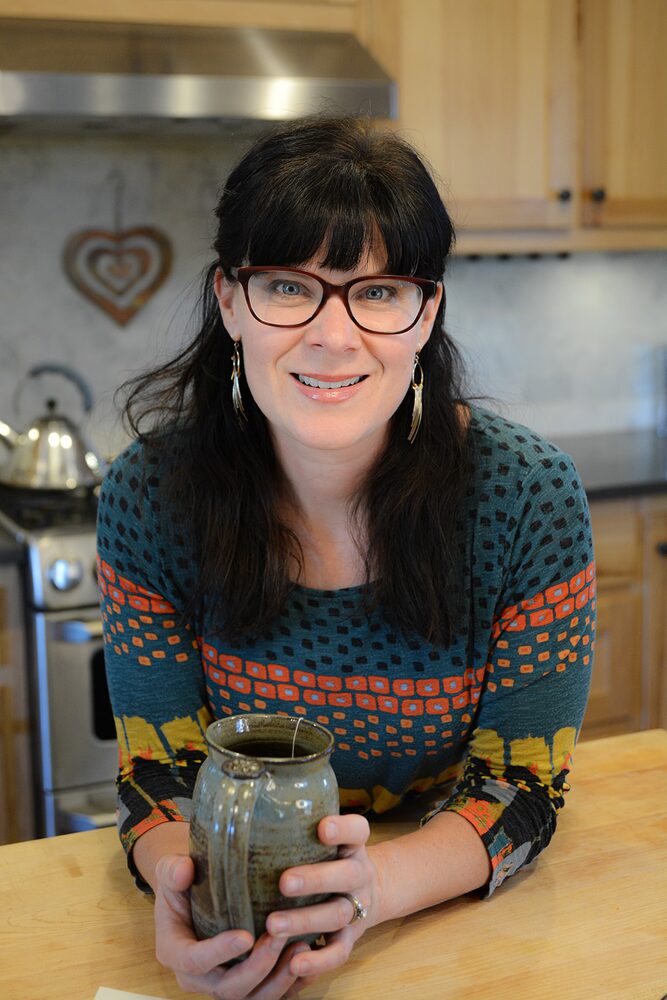 Chelsea Britton holding a mug in her kitchen