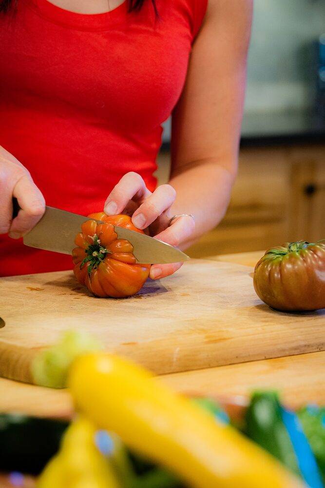 Slicing a tomato on a wooden board