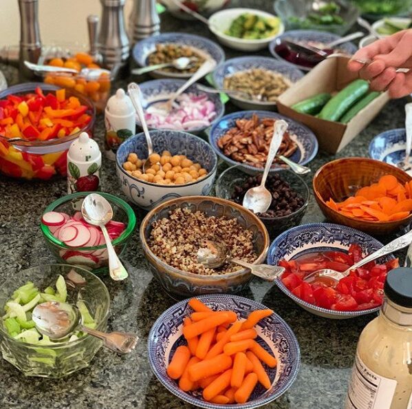A build-your-own taco spread of bowls with vegetables, beans and toppings